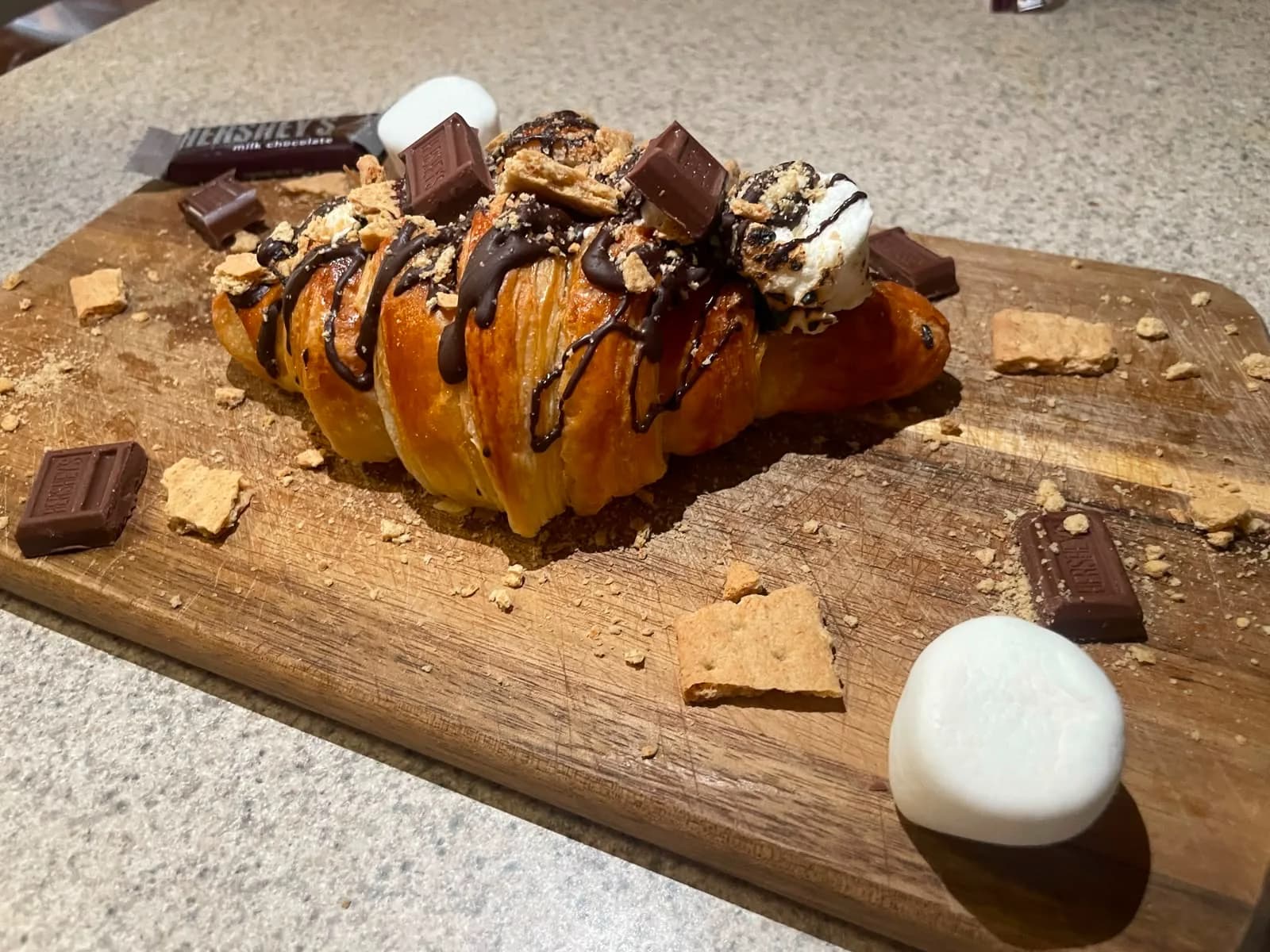 Croissant S'mores con chocolate, galleta graham y bombón flameado